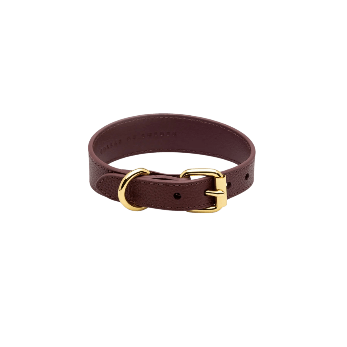 Flat lay of the burgundy vegan leather dog collar with gold hardware by Collar of Sweden – Vue de dessus du collier pour chien en cuir végan couleur bordeaux avec boucle dorée, signé Collar of Sweden – Draufsicht des Hundehalsbands aus burgunderrotem veganem Leder mit goldener Schnalle von Collar of Sweden.