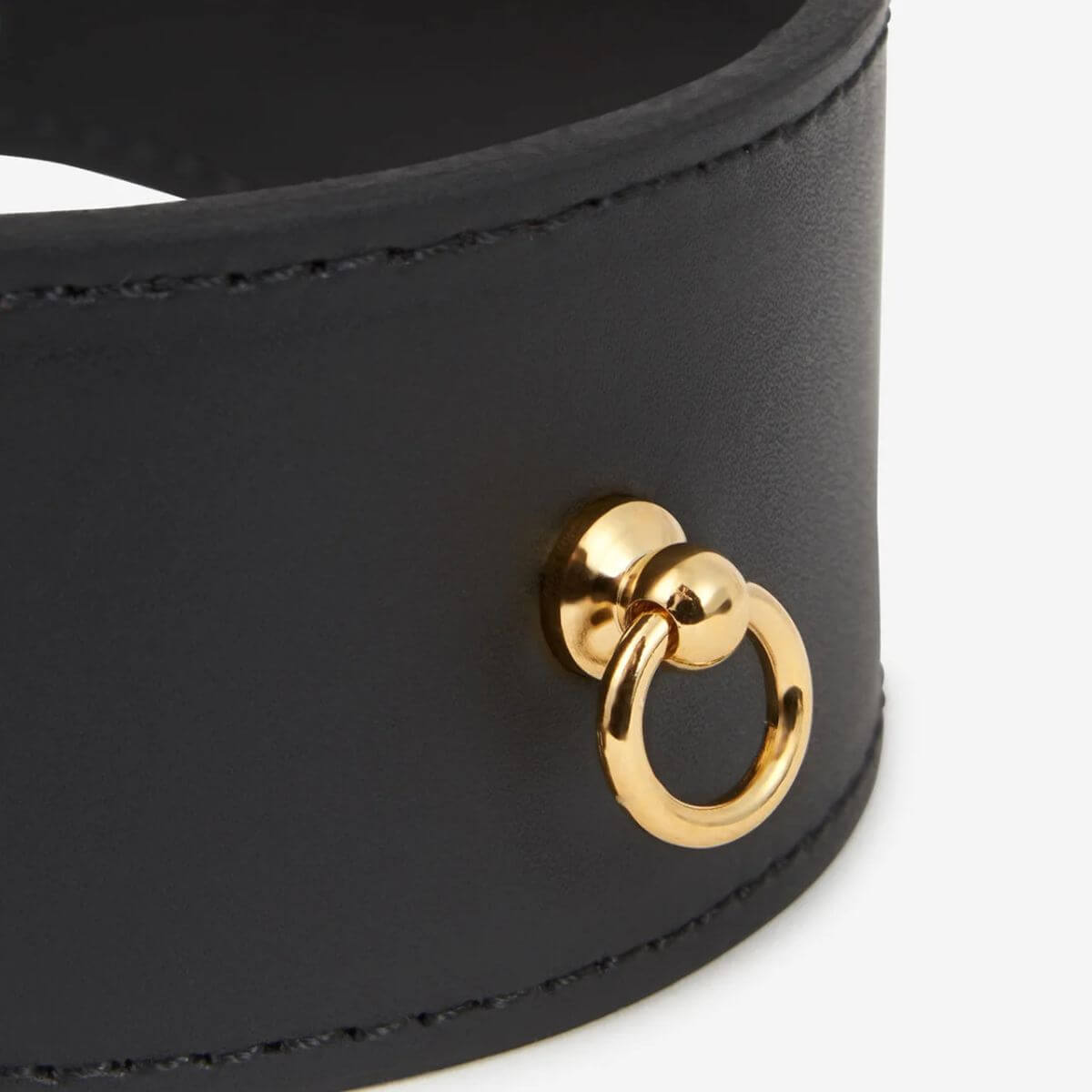 Close-up of the gold ring attachment on a black leather dog collar by Branni Pets, suitable for Greyhounds or dogs with sensitive necks. Nahaufnahme des goldenen Rings an einem schwarzen Lederhalsband von Branni Pets, das für Windhunde oder Hunde mit empfindlichem Hals geeignet ist. Gros plan sur l’anneau doré d’un collier pour chien en cuir noir Branni Pets, adapté aux lévriers ou chiens au cou délicat.