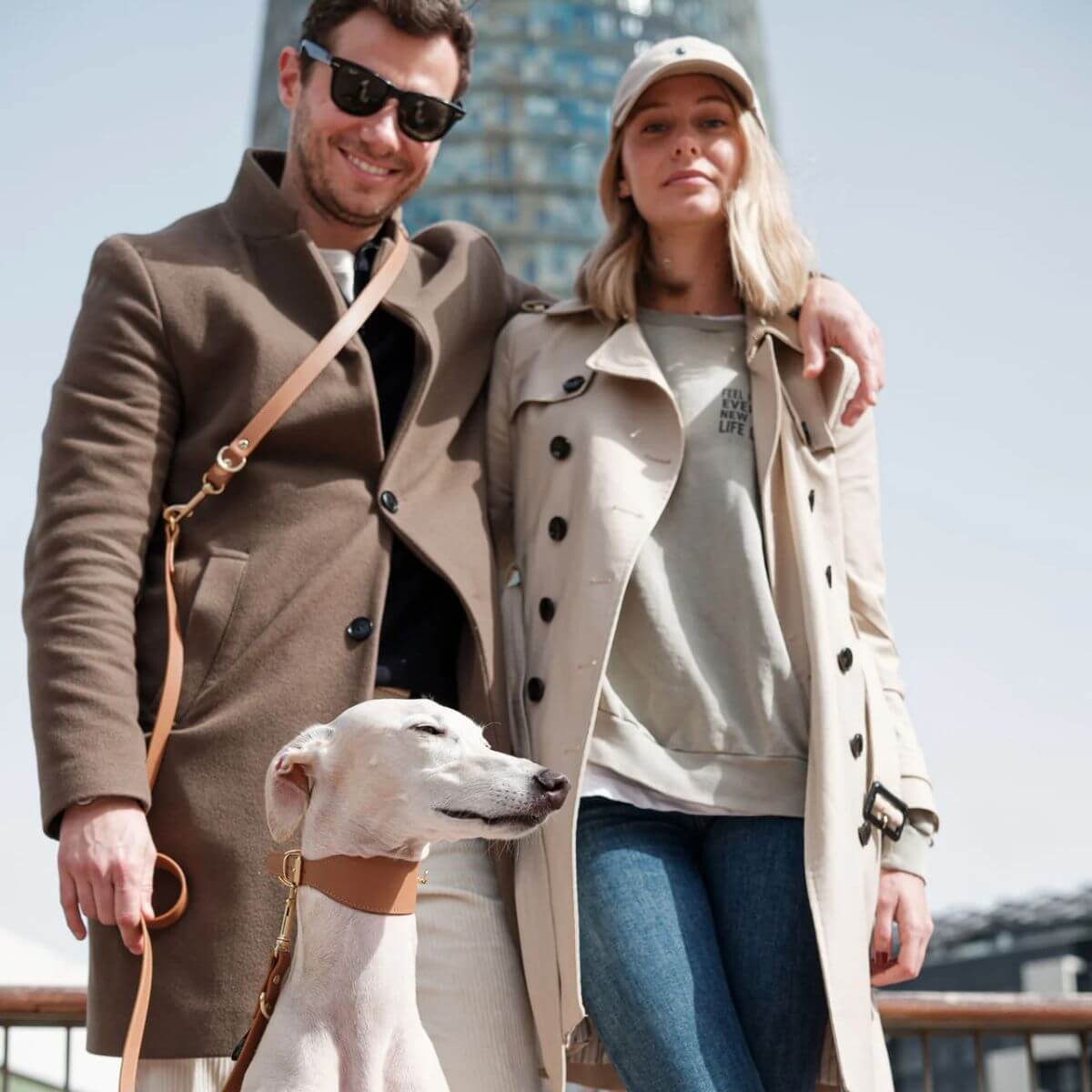 Couple with their dog wearing Branni Pets tan leather collar and leash, posing outdoors.
Paar mit Hund, der das cognacfarbene Halsband und die Leine von Branni Pets trägt, beim Spaziergang draußen.
Couple avec leur chien portant le collier et la laisse camel de Branni Pets, en extérieur.