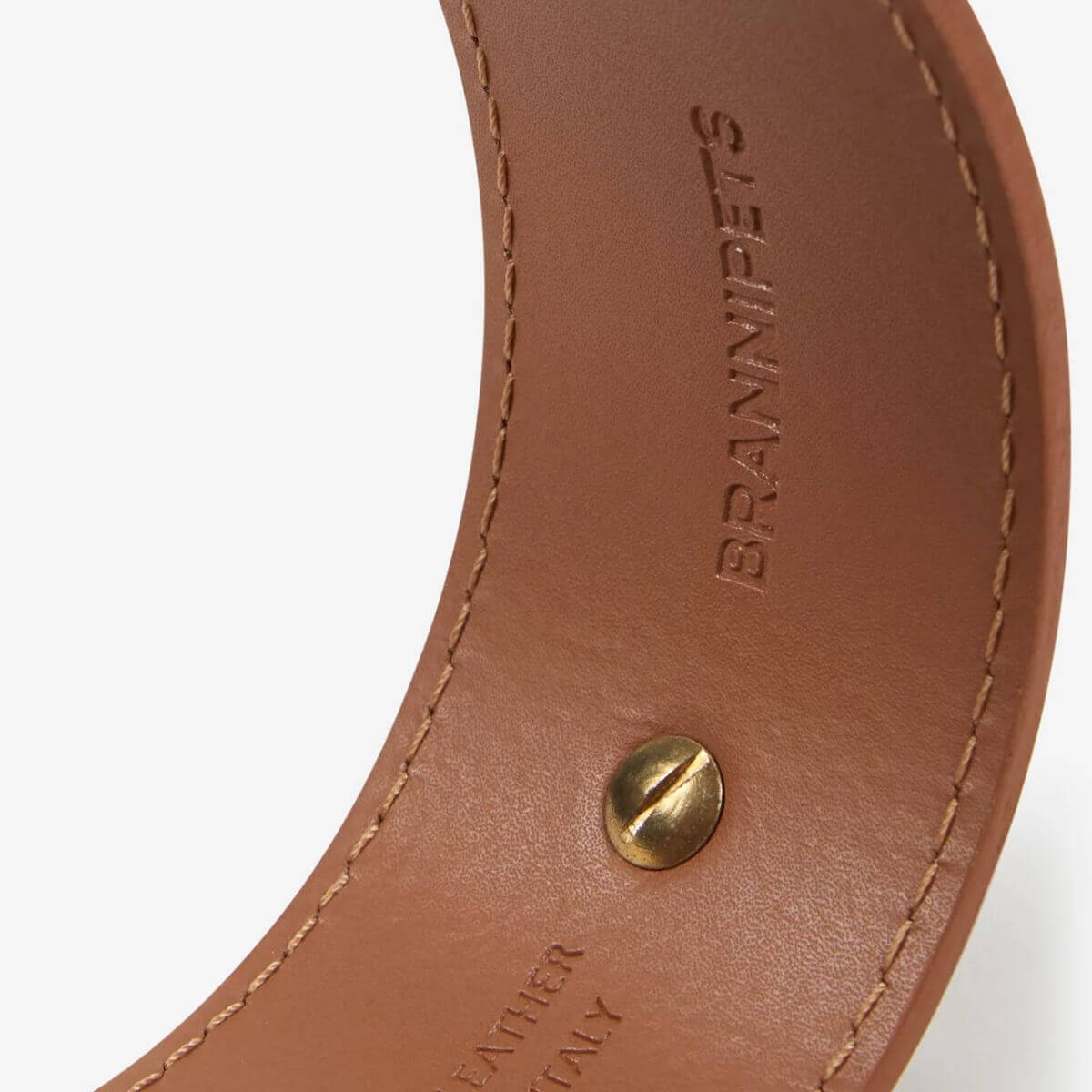 Close-up of the inside of the Branni Pets tan leather collar showing embossed logo and stitching.
Nahaufnahme der Innenseite des cognacfarbenen Halsbands von Branni Pets mit eingeprägtem Logo und Nähten.
Gros plan de l’intérieur du collier camel Branni Pets, avec logo embossé et surpiqûres visibles.