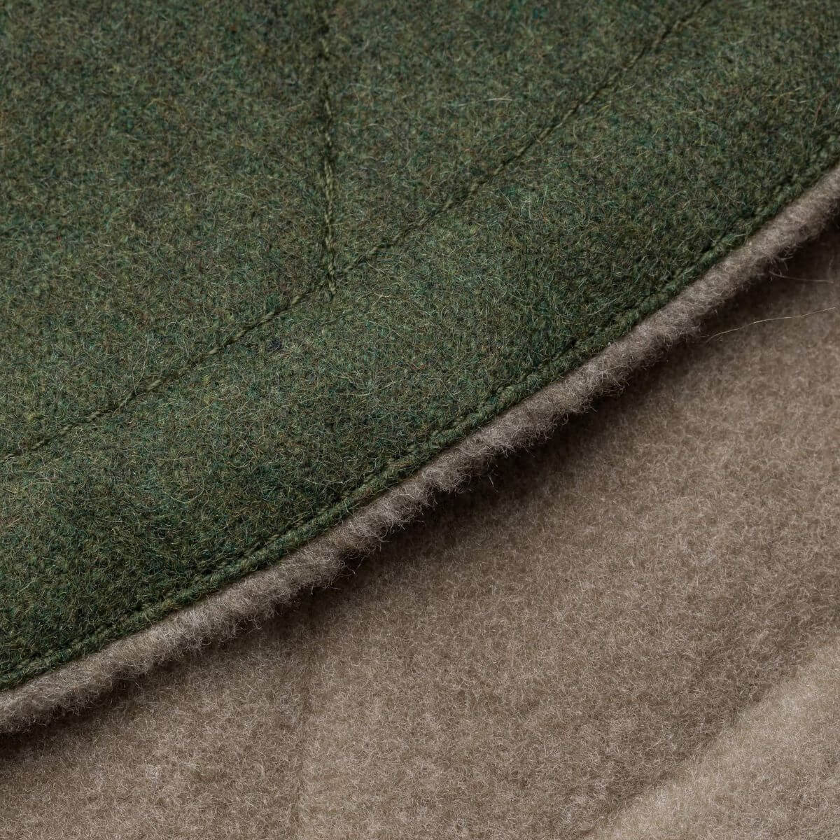 Detail of fabric texture and stitching on Cloud7 green dog wintercoat. | Detailansicht des Stoffs und der Nähte des grünen Cloud7 Hundemantels. | Détail du tissu et des coutures du manteau vert pour chien Cloud7.