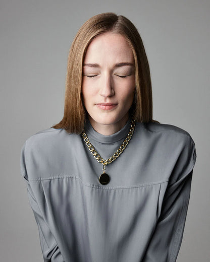 Woman wearing gold chain necklace El Diablo by THE ANIMALS with Disque gold necklace charm