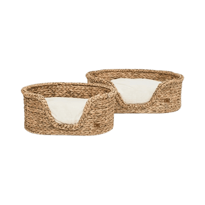 Pair of rattan dog beds from Pet & Co. with removable cream cushions, perfect for a cozy and natural look at home. Zwei Rattan-Hundebetten von Pet & Co. mit herausnehmbaren cremefarbenen Kissen, ideal für ein gemütliches und natürliches Zuhause. Deux paniers pour chien en rotin de Pet & Co. avec coussins crème amovibles, parfaits pour une ambiance chaleureuse et naturelle à la maison.