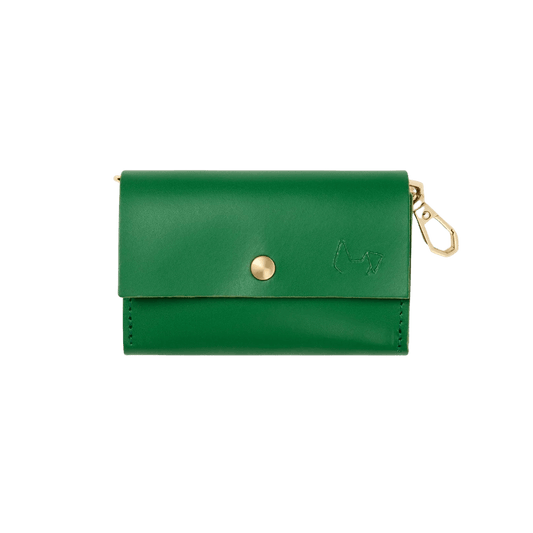Branni Pets poop bag holder in green leather with gold button, embossed logo, and clip. Branni Pets Kotbeutelhalter aus grünem Leder mit goldfarbenem Knopf, geprägtem Logo und Clip. Porte-sacs Branni Pets en cuir vert avec bouton doré, logo embossé et mousqueton.