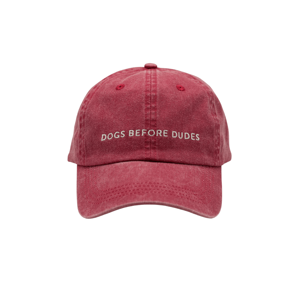 Front view of washed red denim baseball cap with "DOGS BEFORE DUDES" embroidery by Collar of Sweden. Vorderansicht der verwaschenen roten Denim-Basecap mit "DOGS BEFORE DUDES"-Stickerei von Collar of Sweden. Vue de face de la casquette en denim rouge délavé avec broderie "DOGS BEFORE DUDES" de Collar of Sweden.