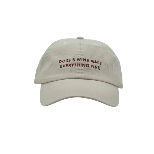 Front view of beige denim baseball cap with embroidered slogan "DOGS & WINE MAKE EVERYTHING FINE" by Collar of Sweden. Vorderansicht der beigefarbenen Denim-Basecap mit gesticktem Slogan "DOGS & WINE MAKE EVERYTHING FINE" von Collar of Sweden. Vue de face de la casquette en denim beige avec slogan brodé "DOGS & WINE MAKE EVERYTHING FINE" de Collar of Sweden.