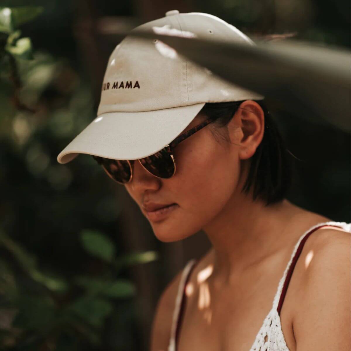 Woman wearing sunglasses and a washed beige denim cap from Collar of Sweden with "FUR MAMA" embroidered on the front – Femme portant des lunettes de soleil et une casquette de Collar of Sweden en jean beige délavé avec l'inscription "FUR MAMA" brodée à l'avant – Frau mit Sonnenbrille und beigefarbener, gewaschener Denim-Kappe von Collar of Sweden mit „FUR MAMA“-Stickerei auf der Vorderseite.