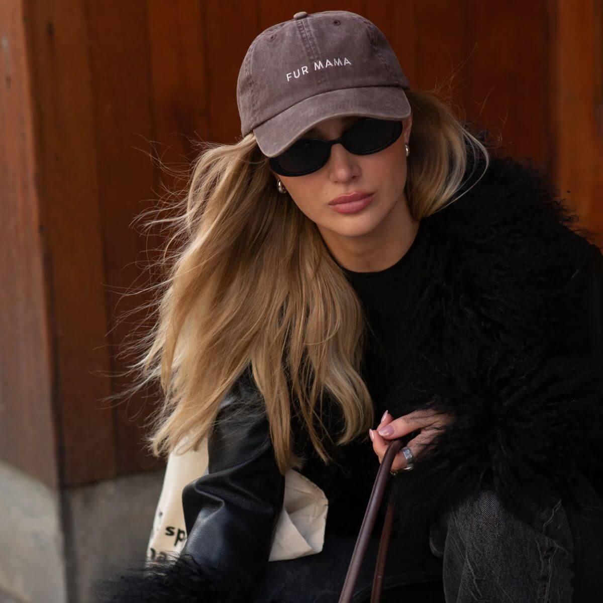 Woman wearing the 'Fur Mama' baseball cap by Collar of Sweden in vintage brown / Femme portant la casquette 'Fur Mama' de Collar of Sweden en brun vintage / Frau mit der Baseballkappe 'Fur Mama' von Collar of Sweden in Vintage-Braun